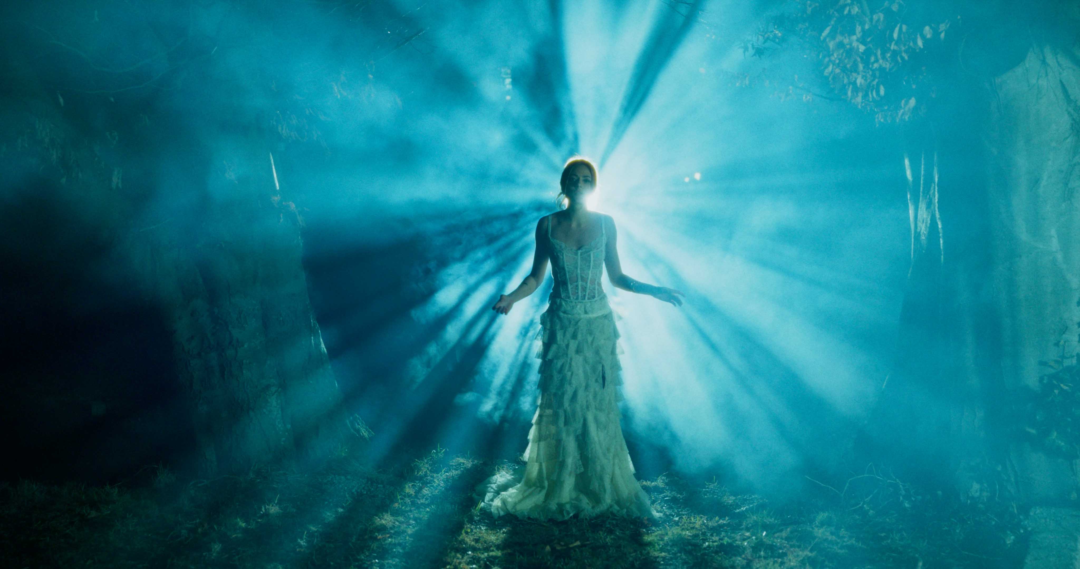 Close-up of a Porsche 911 GT3 rear wing and glowing LED taillight, bathed in deep red tunnel light.